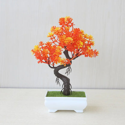Artificial bonsai tree with fiery orange and yellow blossoms, a twisted dark brown trunk, and a sleek white ceramic pot, displayed on a light wood surface—perfect for autumn home décor, cozy indoor accents, and fall-inspired styling.